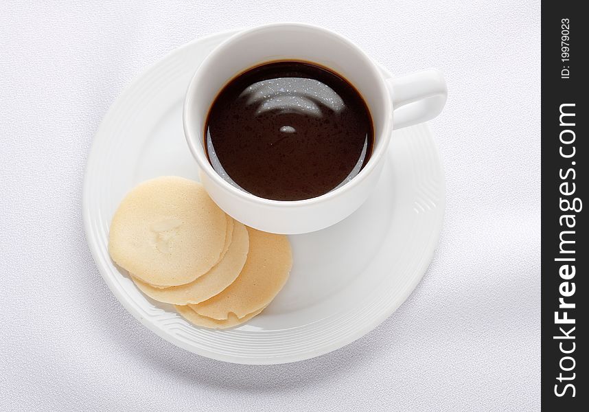 Cup of coffee and tuiles biscuits isolated on white . Cup of coffee and tuiles biscuits isolated on white