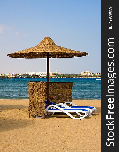 Deck chairs and umbrella in tropical resort beach . Egypt .