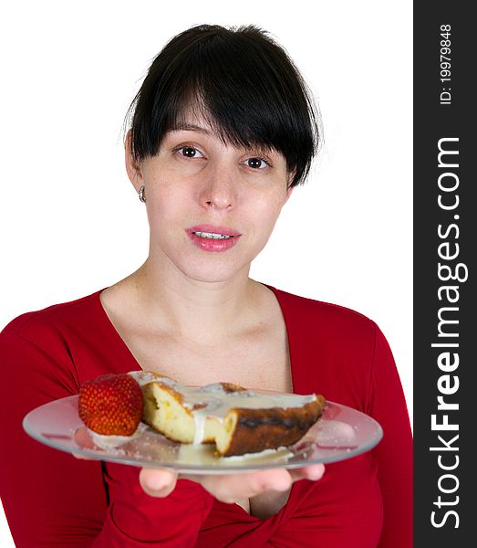 The young girl offers a pie with a strawberry on a plate