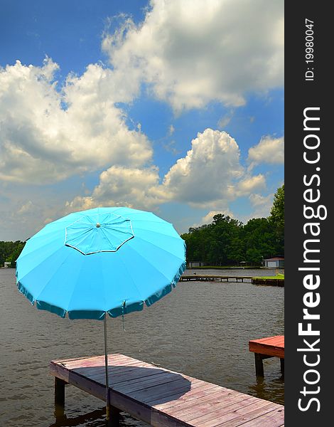 Boat Dock with Umbrella on a lake with clouds