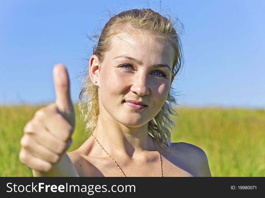 Young beautiful woman showing thumb up and smiles. Young beautiful woman showing thumb up and smiles