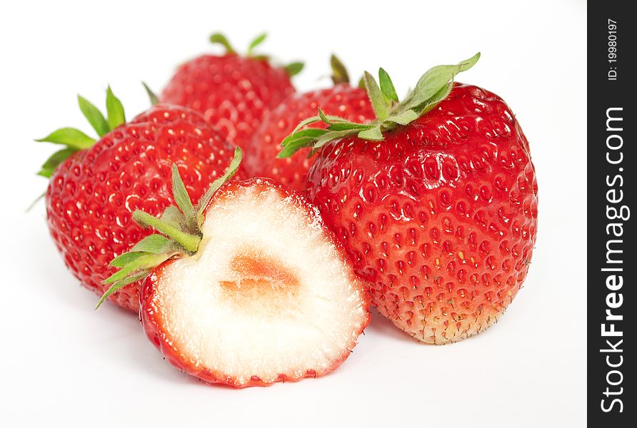 A few ripe strawberries. A one berry is cutted