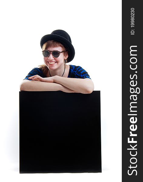 Young woman in black hat and sunglasses on black cube isolated. Young woman in black hat and sunglasses on black cube isolated