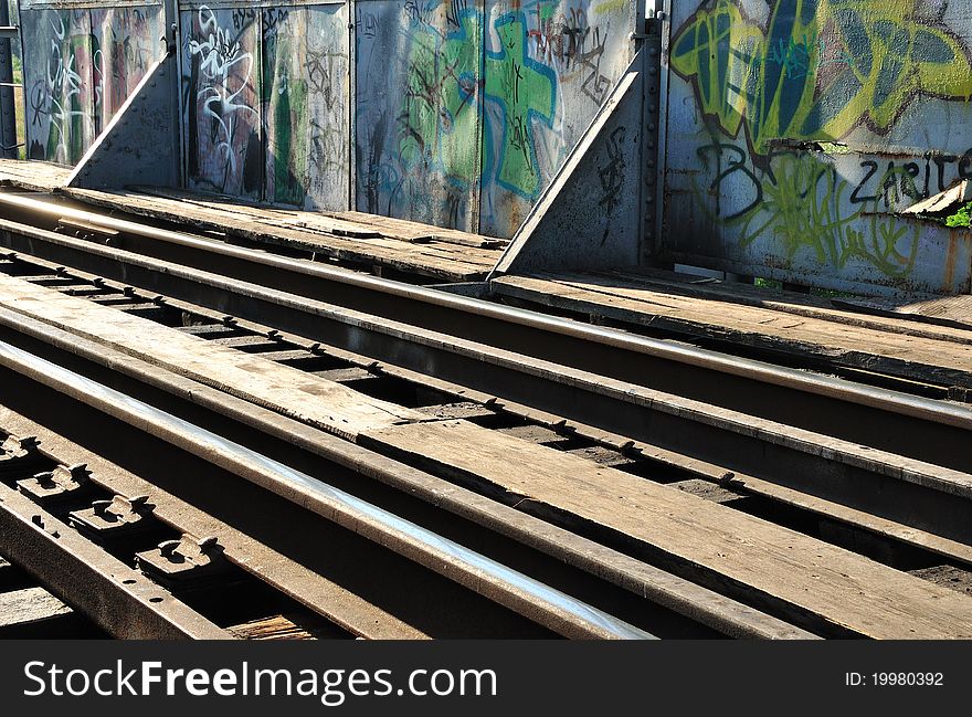 Rails and graffiti on the fence.