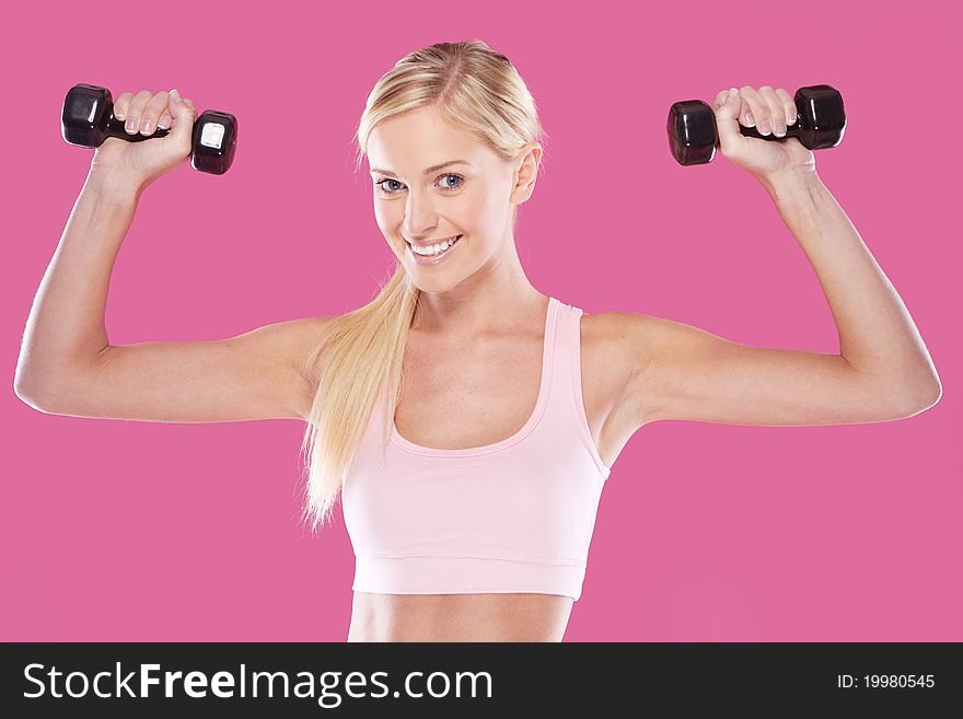 Beautifu happyl blonde fitness model on pink background. Beautifu happyl blonde fitness model on pink background