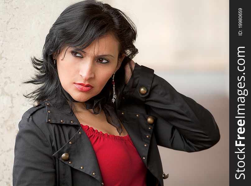 A portrait of a sexy and tough-looking woman in a black jacket and red top. A portrait of a sexy and tough-looking woman in a black jacket and red top