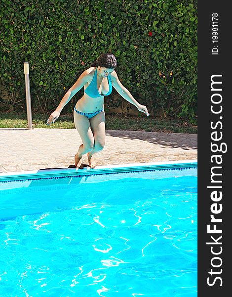 Pretty woman jumping to swimming pool.