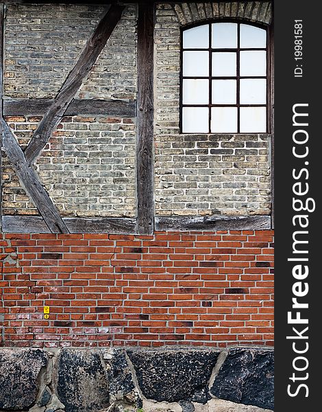 Old brick wall with framework and a window