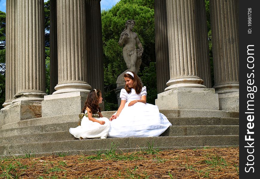 Beautiful girl in her first communion day with her little sister