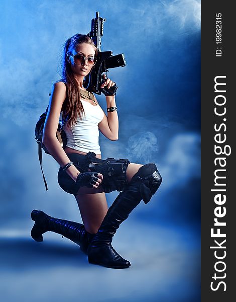 Shot of a military woman posing with guns. Shot of a military woman posing with guns.