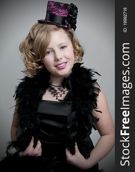 Adorable child model wearing feather boa and fancy hat. Adorable child model wearing feather boa and fancy hat