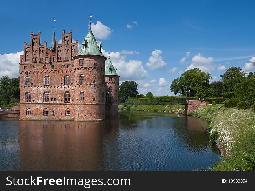 Old brick castle at the lake against blue sky with clouds. Old brick castle at the lake against blue sky with clouds.