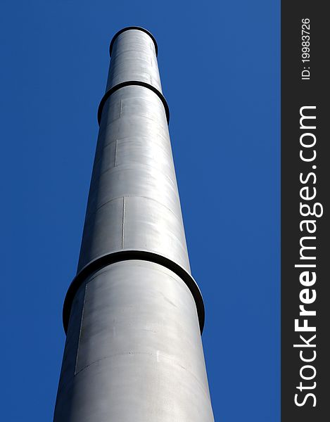 View From Below of a Tall Smoke Stack on a Blue Sky