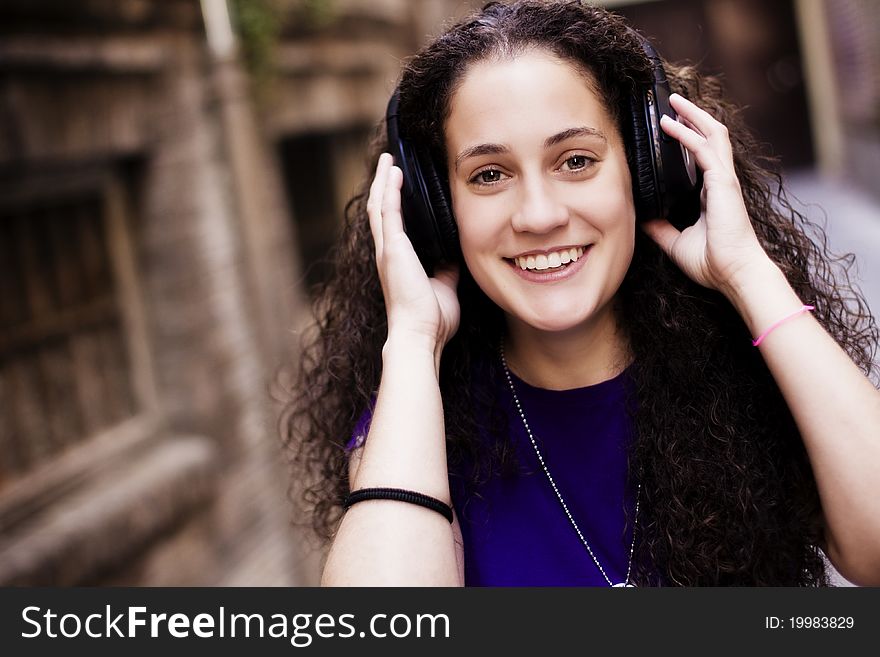 Young beautiful girl enjoying music from her headphones. Young beautiful girl enjoying music from her headphones.