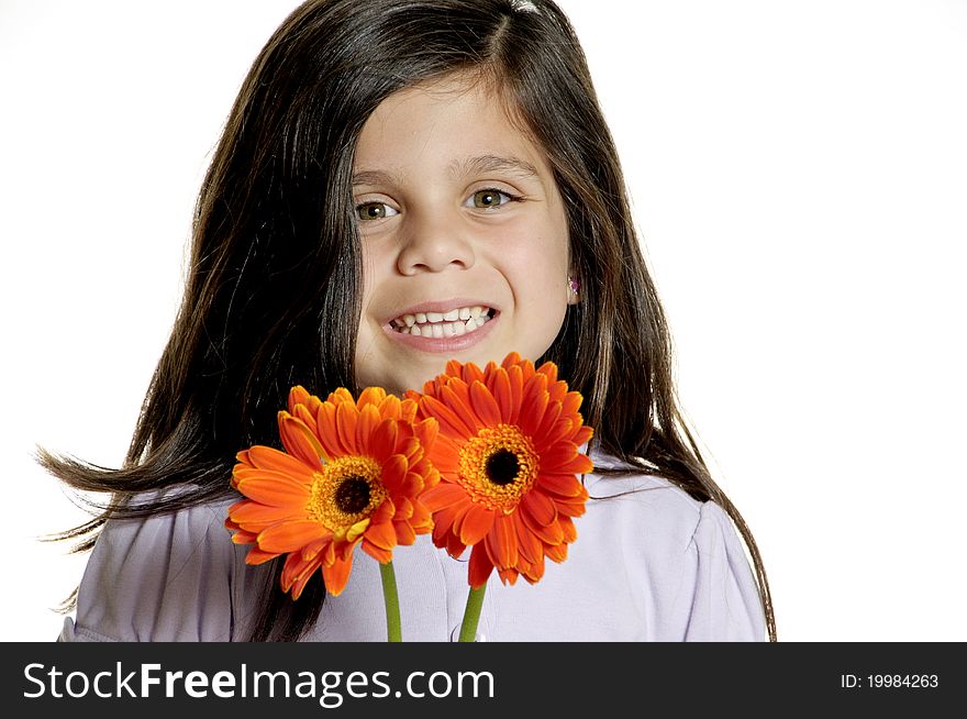 A little girl holding a flower in front of her face with a cheerful look. A little girl holding a flower in front of her face with a cheerful look.