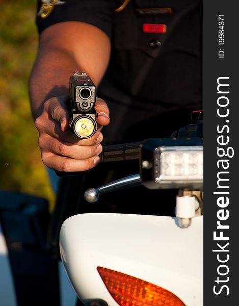 A police officer pointing his gun while sitting on his motorcycle. A police officer pointing his gun while sitting on his motorcycle.