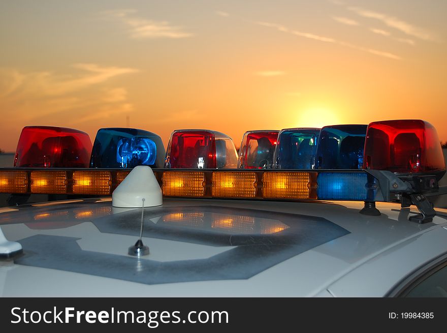 The lightbar on top of the roof of a police car in Anaheim,CA at sunset. The lightbar on top of the roof of a police car in Anaheim,CA at sunset.