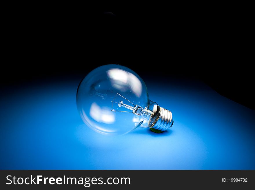 Light Bulb on place blue floor with light from above. Light Bulb on place blue floor with light from above