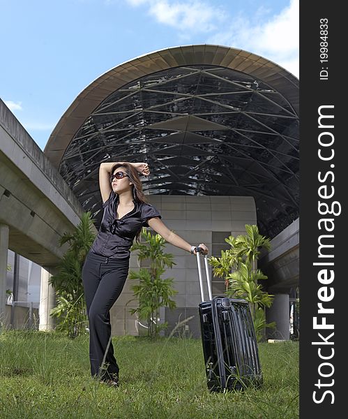 Picture of an asian chinese lady posing with her luggage. With growing economic boom in china and asia, most are taking to traveling. Picture of an asian chinese lady posing with her luggage. With growing economic boom in china and asia, most are taking to traveling.