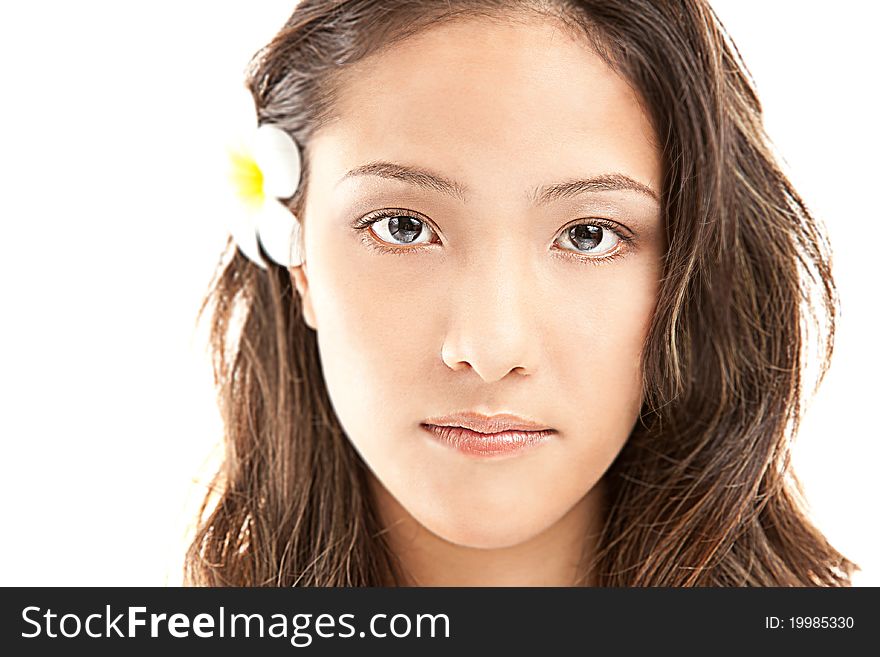 Beautiful asian female face with big eyes and flower from ear isolated on white. Beautiful asian female face with big eyes and flower from ear isolated on white