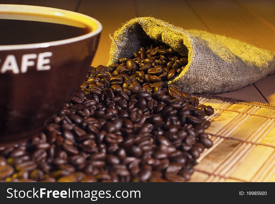 Coffee beans and cup of coffee on the table. Coffee beans and cup of coffee on the table