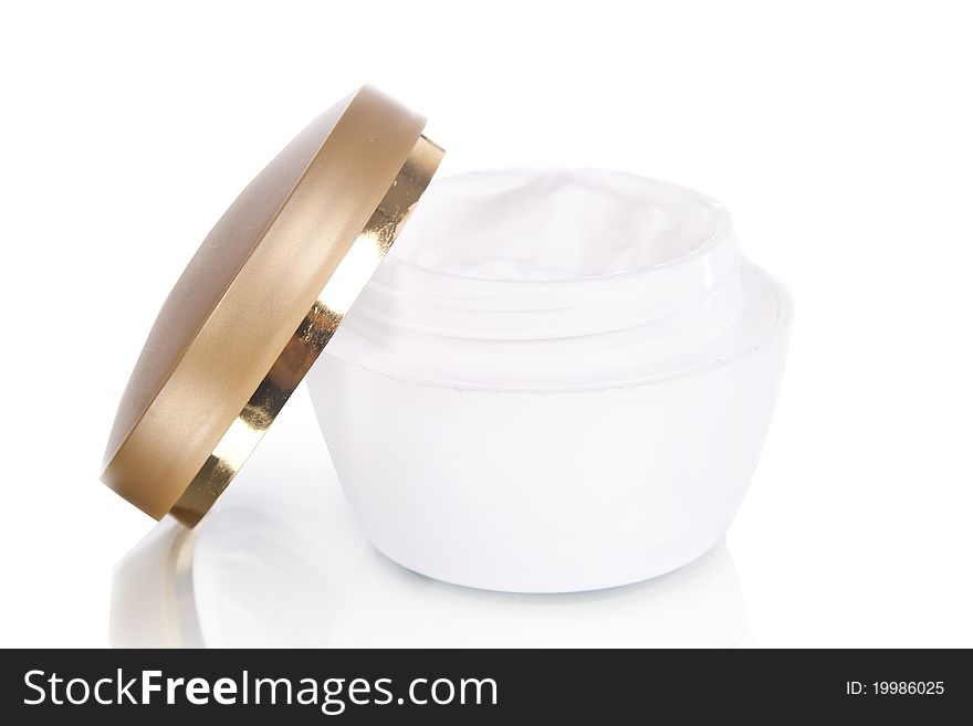 Opened ceramic container with cream with gold lid