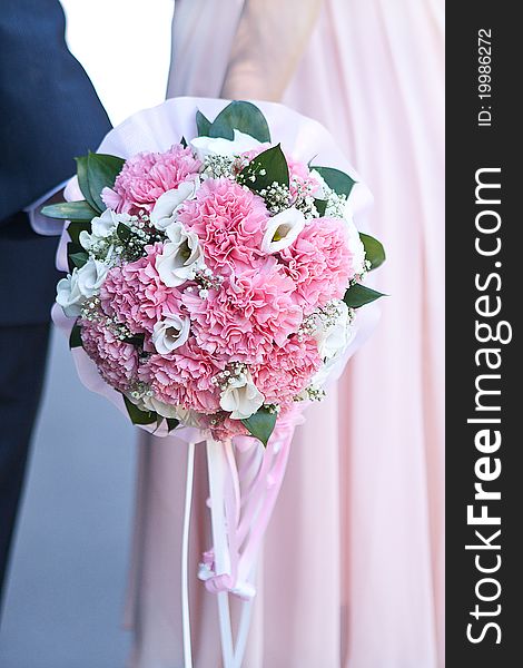 Bride and groom holding bouquet together. Bride and groom holding bouquet together