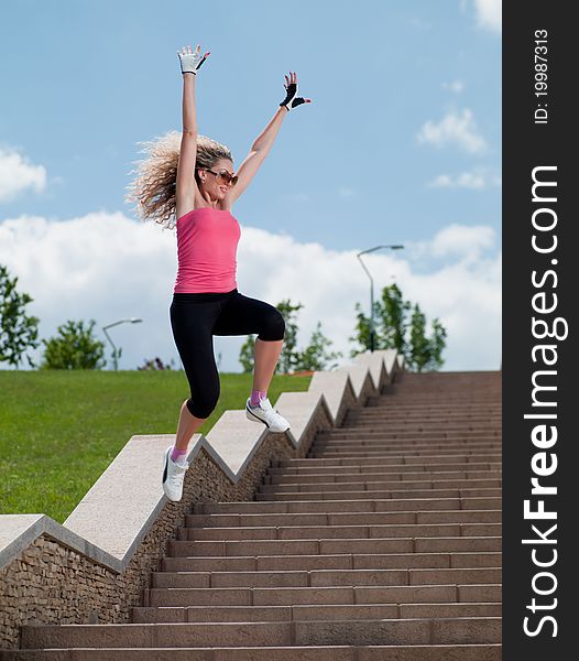 Woman in sportswear jumping over the stairs