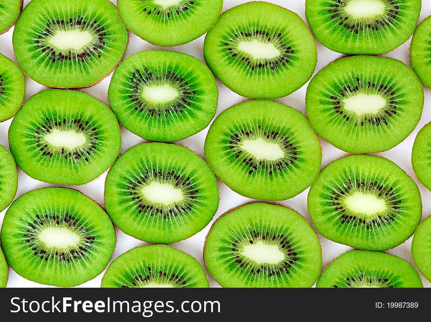 Kiwi, cut into slices laid on a white background