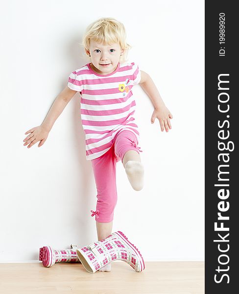 Little girl putting on rubber boots