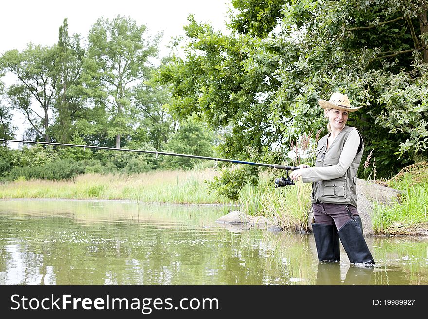 Similing woman fishing in pond. Similing woman fishing in pond