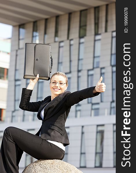 Sitting young businesswoman with a briefcase