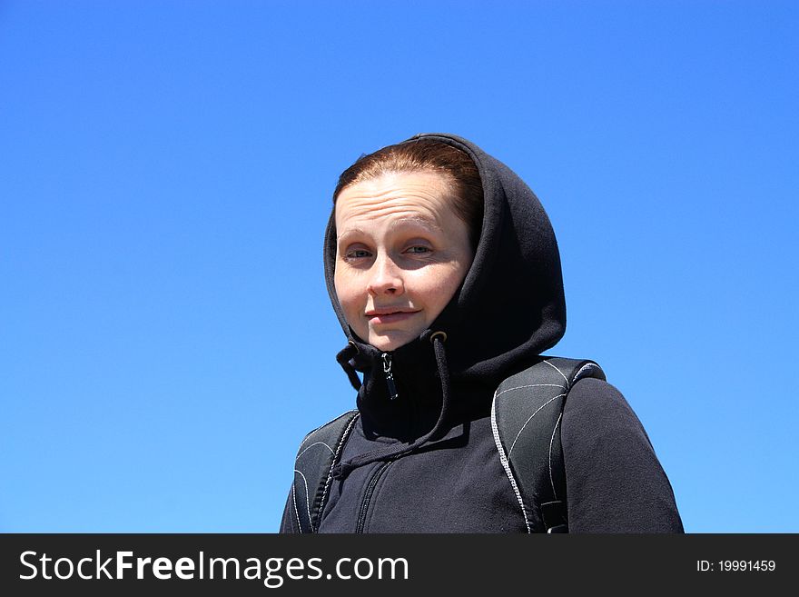 Portrait of a woman in the hood against the blue sky. Portrait of a woman in the hood against the blue sky.
