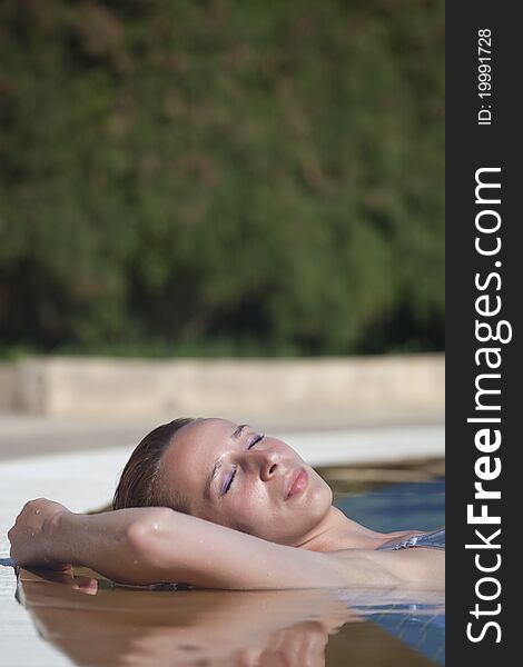 Woman sunbathing in swimming pool