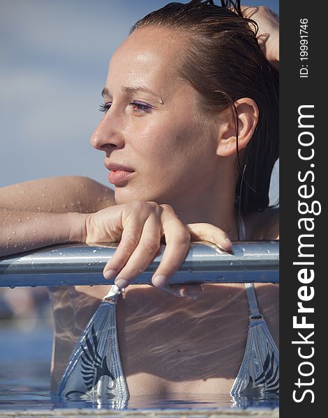 Woman in swimming pool resting on the bar