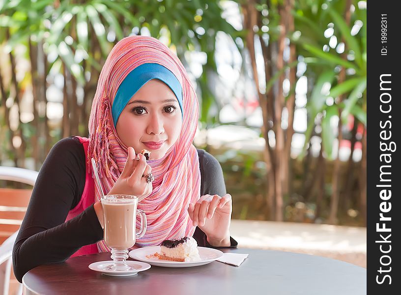 Young muslim woman relaxed while eating a cakes. Young muslim woman relaxed while eating a cakes