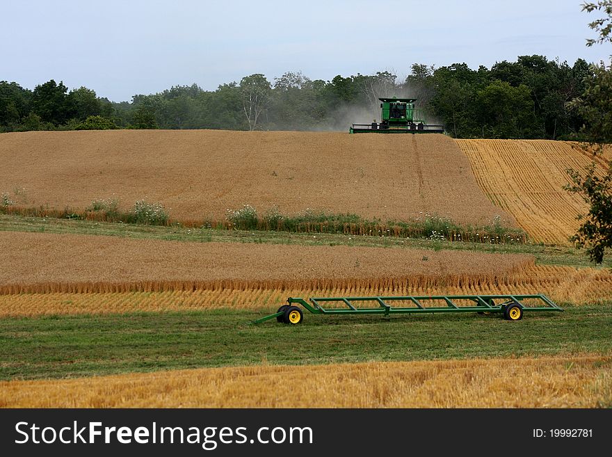 A combine harvests a field of wheat. A combine harvests a field of wheat.