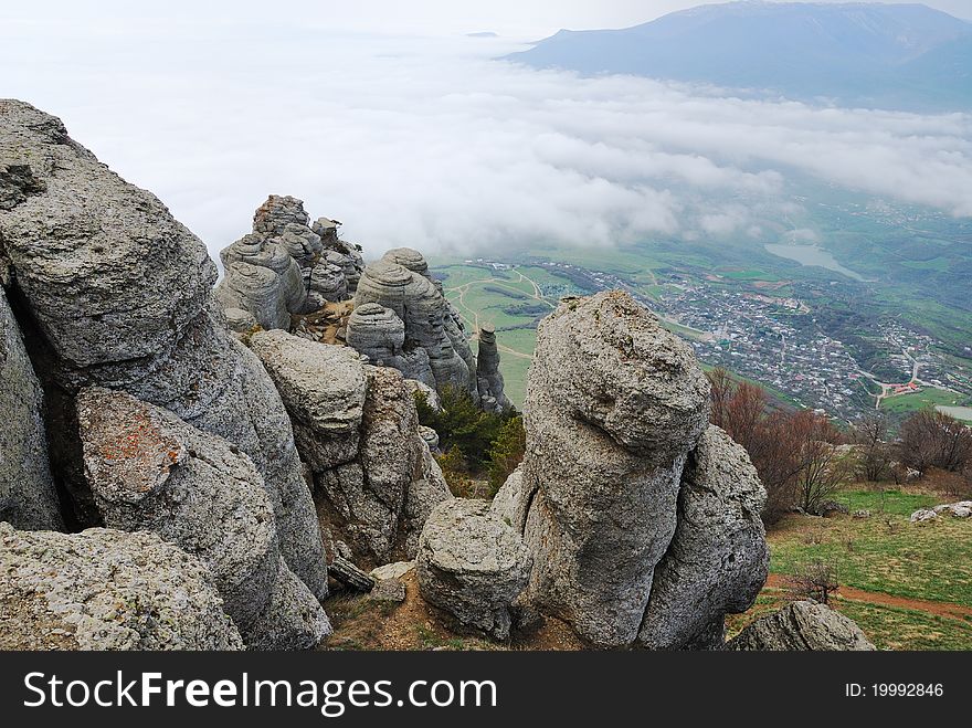 The fanciful rocks of Demirji are photographed from above. The green valley with small town is located below. The fanciful rocks of Demirji are photographed from above. The green valley with small town is located below.