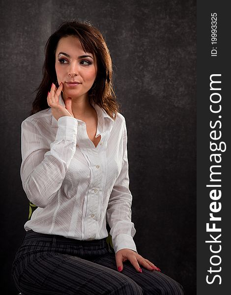 Portrait of an attractive woman in a white blouse on a black background