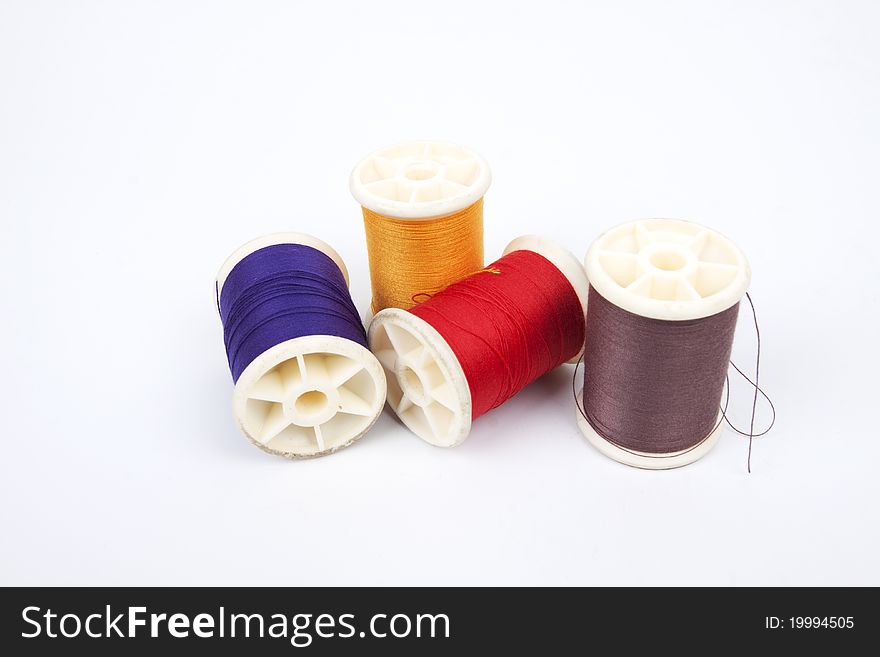 Four different colors of spools thread.