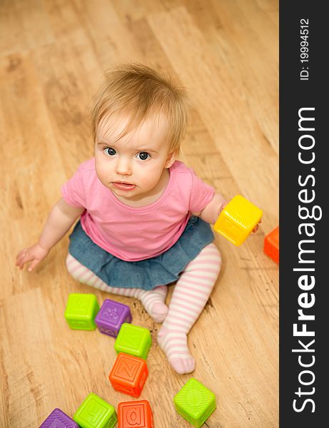 Cute little girl playing with plastic blocks