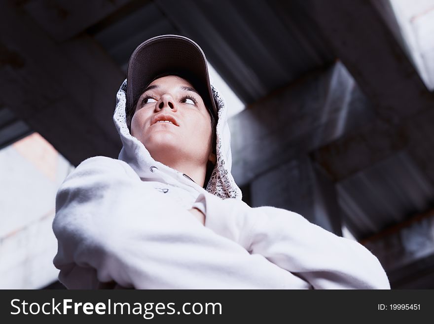 Portrait of cool young girl with cap and white hoody pullover in factory hall. Portrait of cool young girl with cap and white hoody pullover in factory hall.