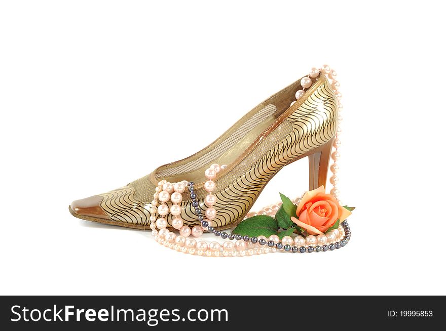 Woman golden shoe with pearl necklace   on a white background