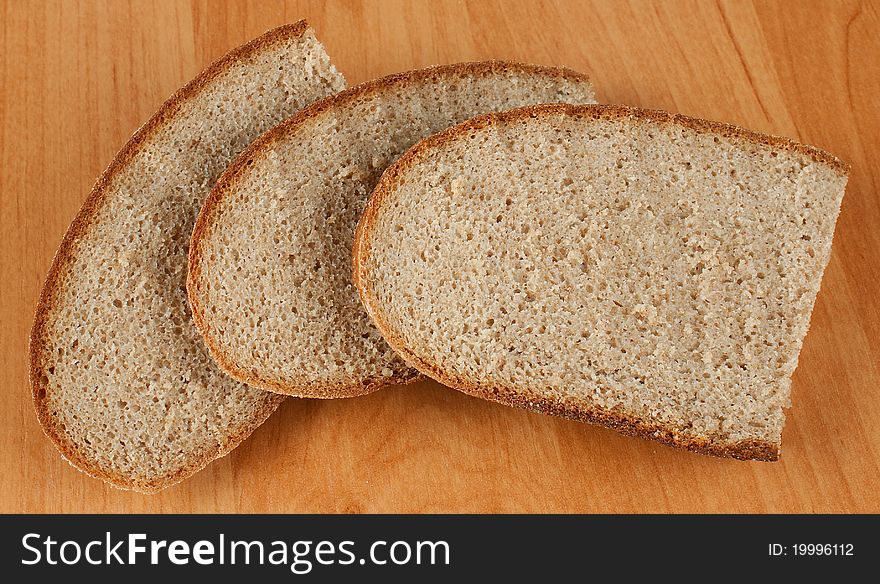 Black pieces of fresh bread on a wooden table. Black pieces of fresh bread on a wooden table