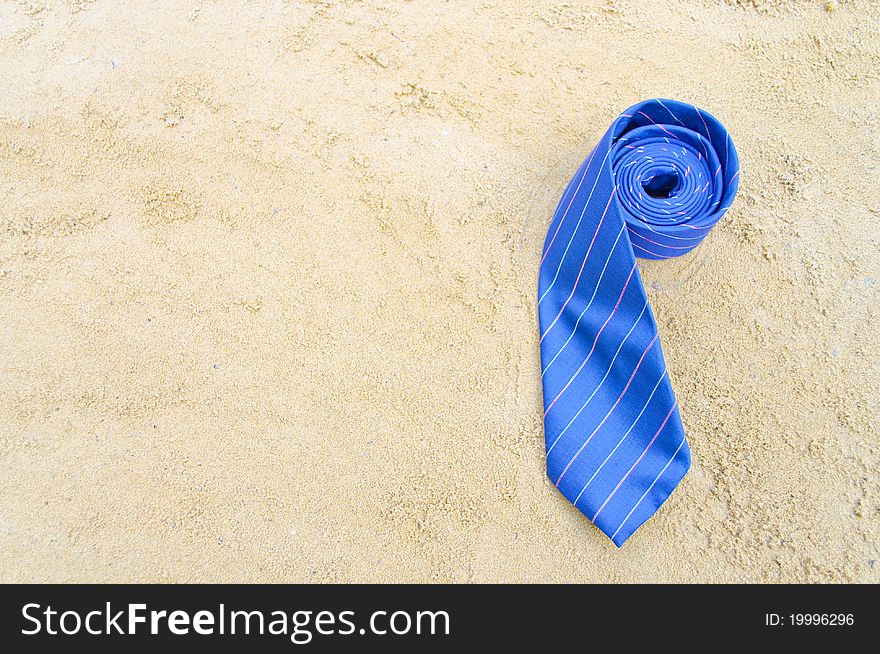 Striped blue necktie on the sandy beach. Striped blue necktie on the sandy beach