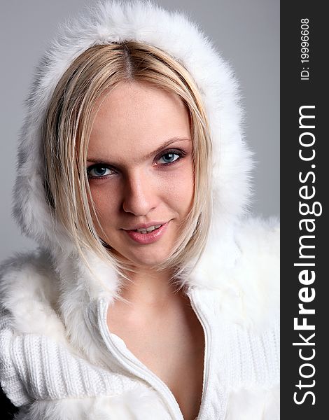 Pretty blond girl in a white hood smiling