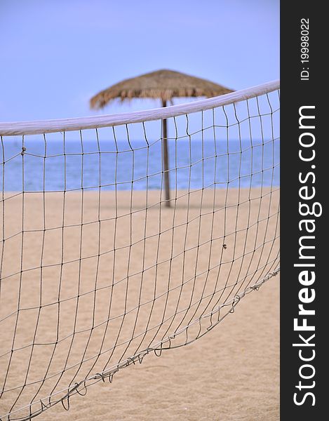 Sunshade and sand volleyball net on beach
