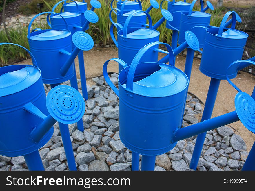 Three rows of Blue watering cans.