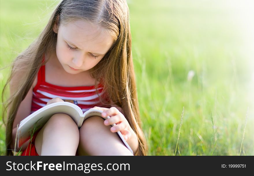 Girl with long hair, reading a book