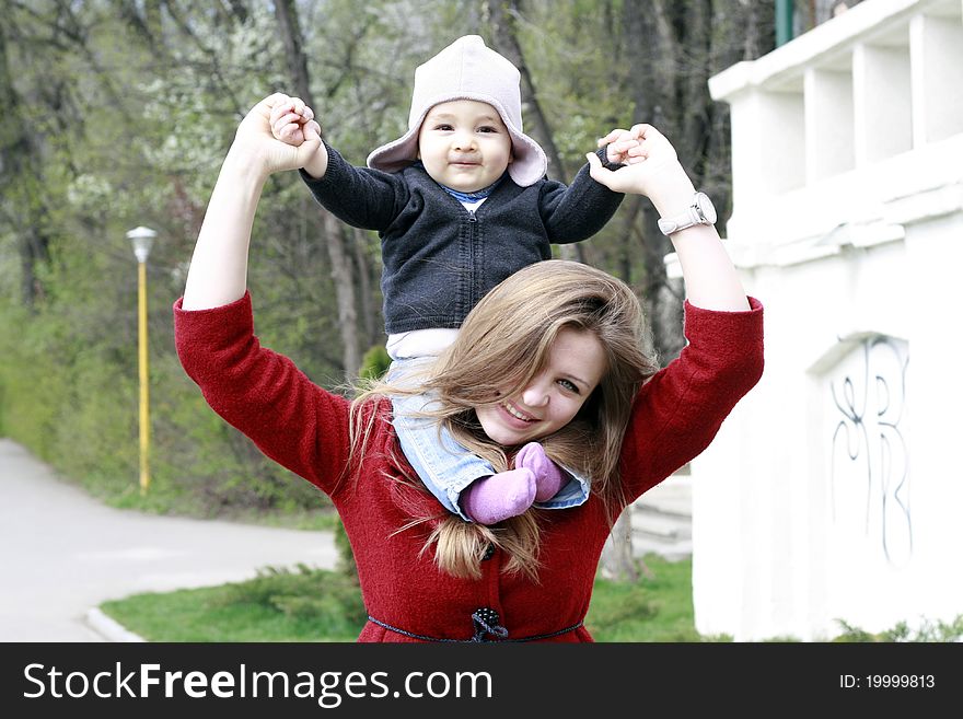 Mother carrying her baby boy on her shoulders. Mother carrying her baby boy on her shoulders